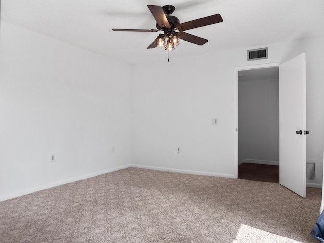 empty room featuring a ceiling fan, carpet, and baseboards