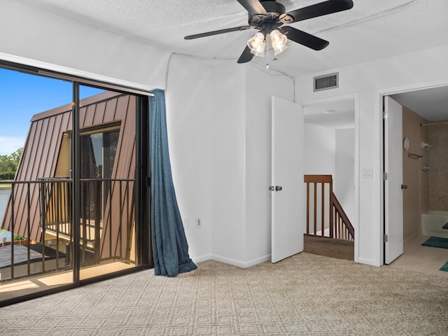 carpeted empty room featuring a textured ceiling, ceiling fan, and baseboards