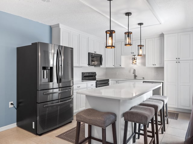 kitchen featuring appliances with stainless steel finishes, a sink, light tile patterned floors, light countertops, and a textured ceiling