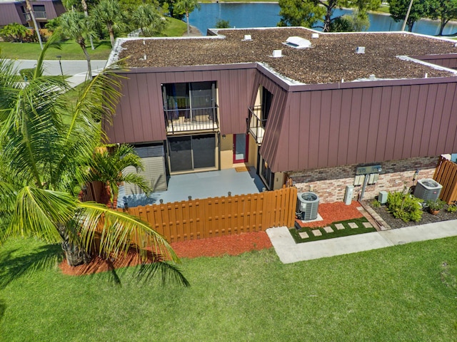 rear view of property with central air condition unit and a water view