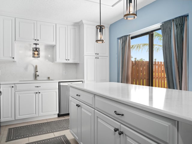 kitchen featuring a sink, dishwasher, white cabinets, light countertops, and a textured ceiling