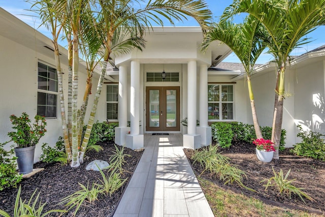 view of exterior entry featuring french doors and stucco siding