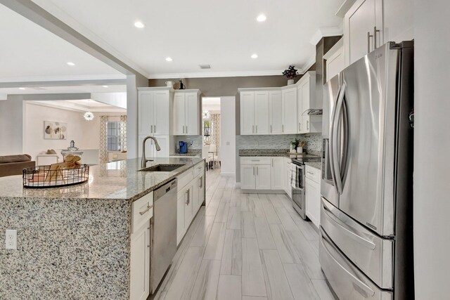 kitchen featuring stainless steel appliances, a sink, ornamental molding, a spacious island, and decorative backsplash