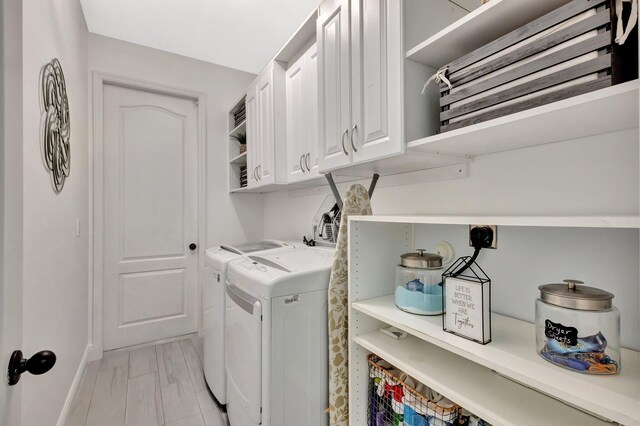 laundry area with washer and dryer, cabinet space, and baseboards