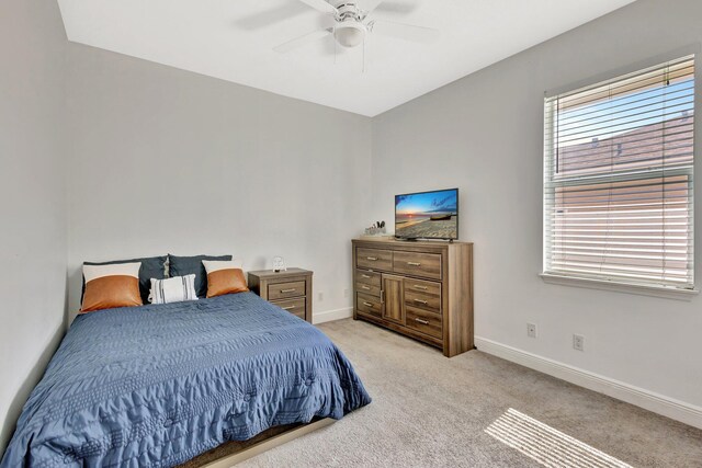 bedroom with baseboards, light carpet, and a ceiling fan