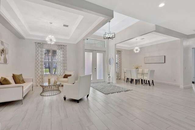 living area with a chandelier, a tray ceiling, baseboards, light wood-type flooring, and recessed lighting
