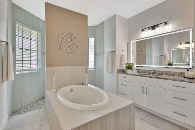 full bathroom with tile patterned flooring, a garden tub, and vanity