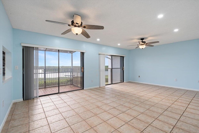 empty room featuring a ceiling fan, recessed lighting, baseboards, a water view, and light tile patterned flooring