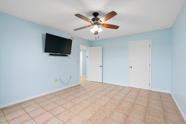 spare room featuring a ceiling fan, a textured ceiling, and baseboards