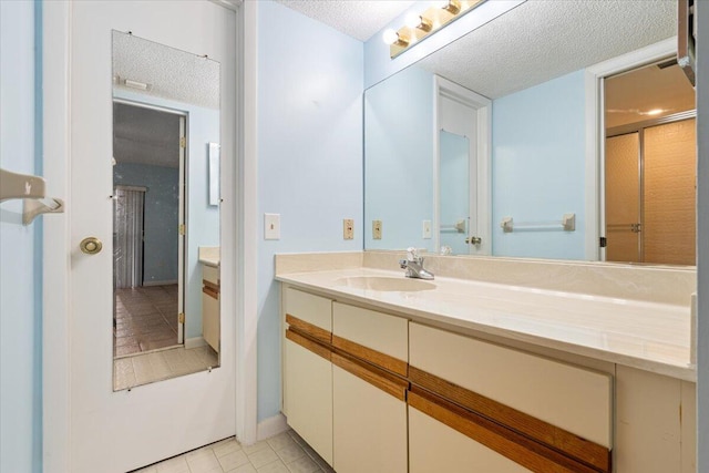 bathroom featuring a textured ceiling, vanity, and tile patterned floors