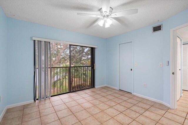 unfurnished bedroom featuring access to outside, a textured ceiling, light tile patterned floors, baseboards, and ceiling fan