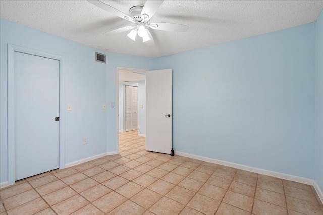 unfurnished bedroom with a textured ceiling, ceiling fan, and baseboards