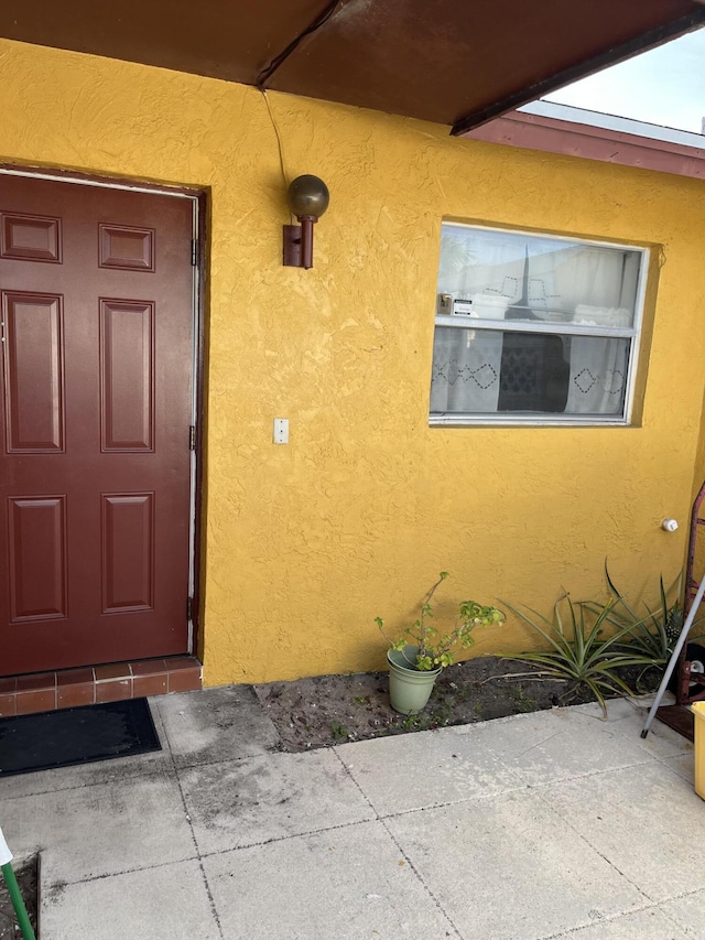 property entrance with stucco siding