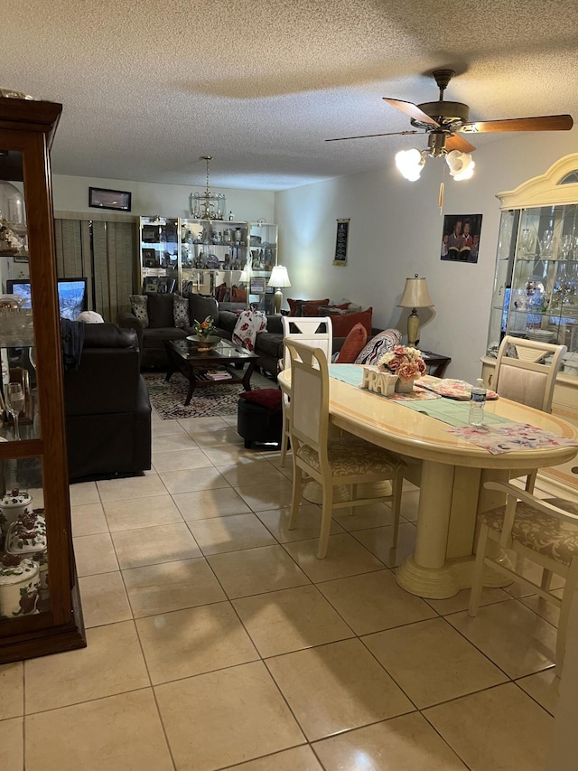 dining area with light tile patterned floors, a textured ceiling, and a ceiling fan
