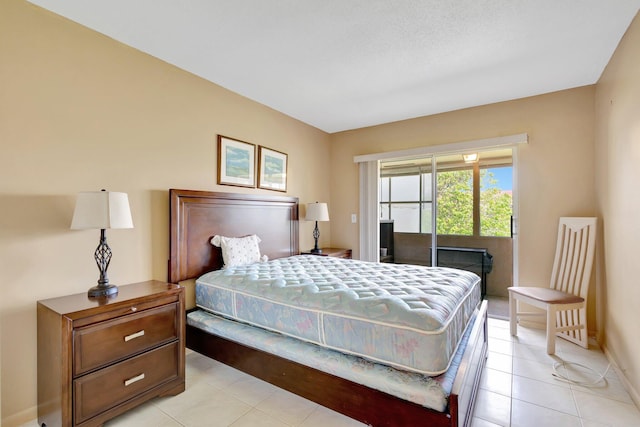 bedroom with light tile patterned floors, access to exterior, and baseboards
