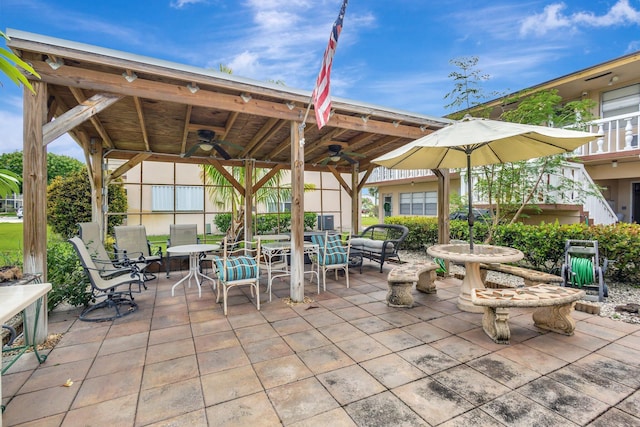 view of patio featuring ceiling fan, outdoor dining space, and a gazebo