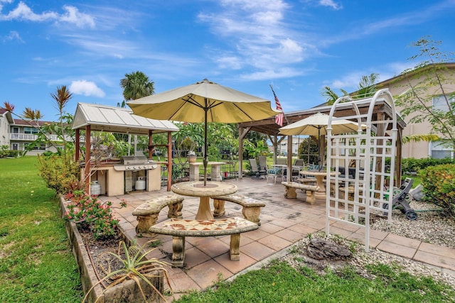view of patio featuring exterior kitchen, a grill, and a gazebo