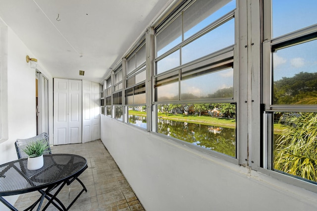 sunroom / solarium featuring a water view