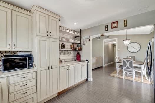 701 SW 1st Ave S, Boynton Beach, FL 33426 - kitchen featuring light countertops, open shelves, decorative light fixtures, wood finished floors, and baseboards