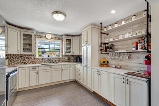 701 SW 1st Ave S, Boynton Beach, FL 33426 - kitchen featuring stainless steel electric range, decorative backsplash, a sink, and light countertops