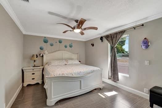 701 SW 1st Ave S, Boynton Beach, FL 33426 - bedroom with baseboards, ornamental molding, ceiling fan, and dark wood finished floors