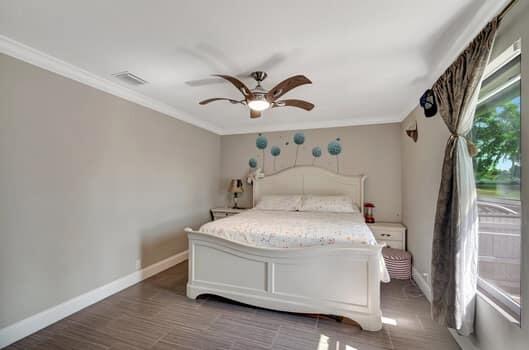 701 SW 1st Ave S, Boynton Beach, FL 33426 - bedroom with crown molding, baseboards, and a ceiling fan