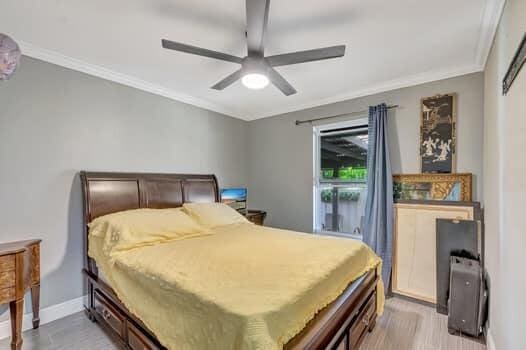 701 SW 1st Ave S, Boynton Beach, FL 33426 - bedroom featuring ornamental molding, baseboards, light wood-style flooring, and ceiling fan