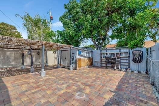 701 SW 1st Ave S, Boynton Beach, FL 33426 - view of patio / terrace with a fenced backyard, a shed, an outbuilding, and a pergola