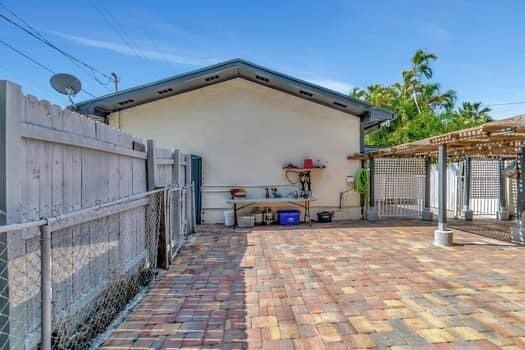 701 SW 1st Ave S, Boynton Beach, FL 33426 - view of property exterior with fence, a pergola, and stucco siding
