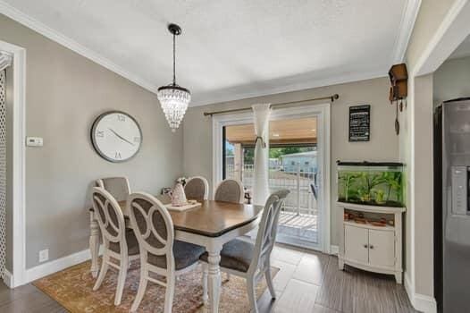 701 SW 1st Ave S, Boynton Beach, FL 33426 - dining room with ornamental molding, baseboards, a chandelier, and wood finished floors