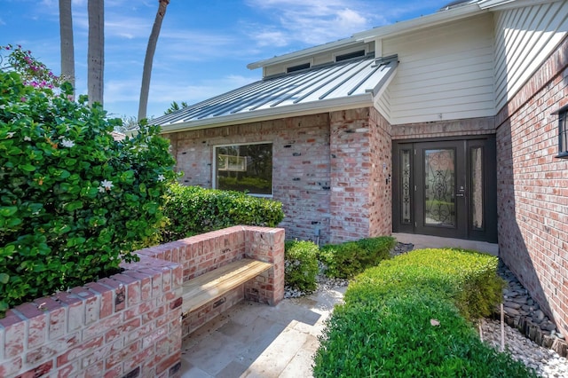 entrance to property with a standing seam roof, brick siding, and metal roof