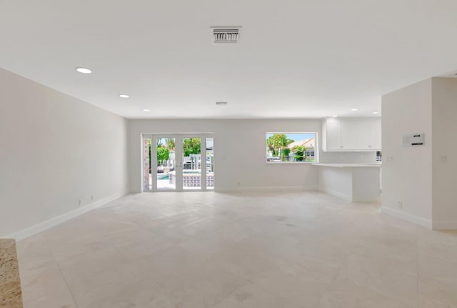 unfurnished living room featuring french doors, baseboards, and recessed lighting