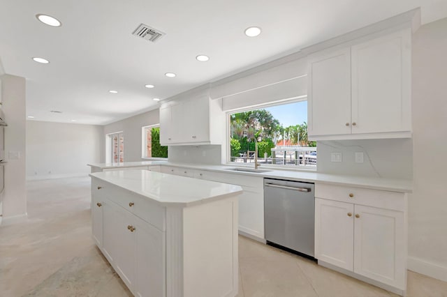 kitchen with stainless steel dishwasher, a sink, recessed lighting, white cabinets, and a center island