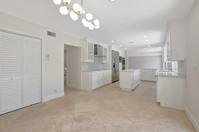 kitchen with a center island, white cabinetry, high end fridge, a sink, and black electric cooktop