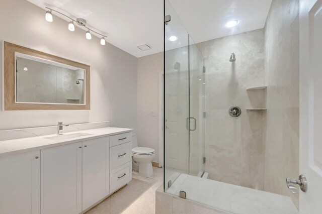 bathroom with a shower stall, vanity, and toilet