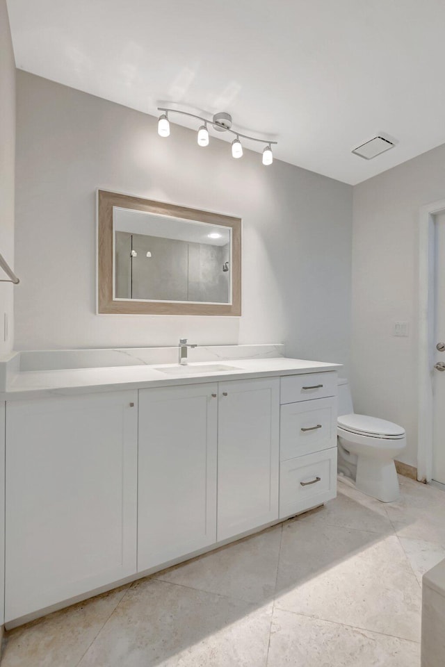 bathroom featuring toilet, tile patterned floors, and vanity