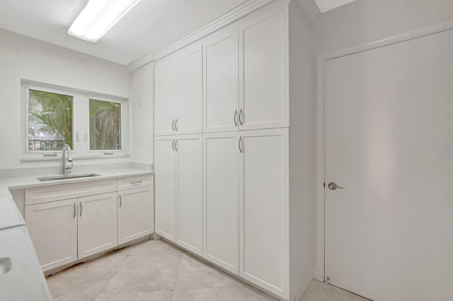 laundry area featuring a sink and light tile patterned flooring