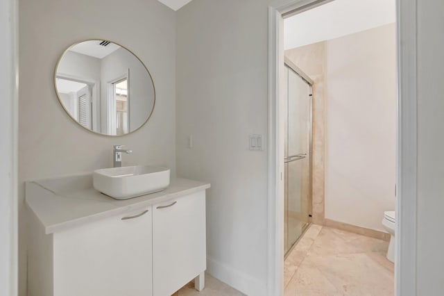 full bathroom with a shower stall, toilet, baseboards, and vanity