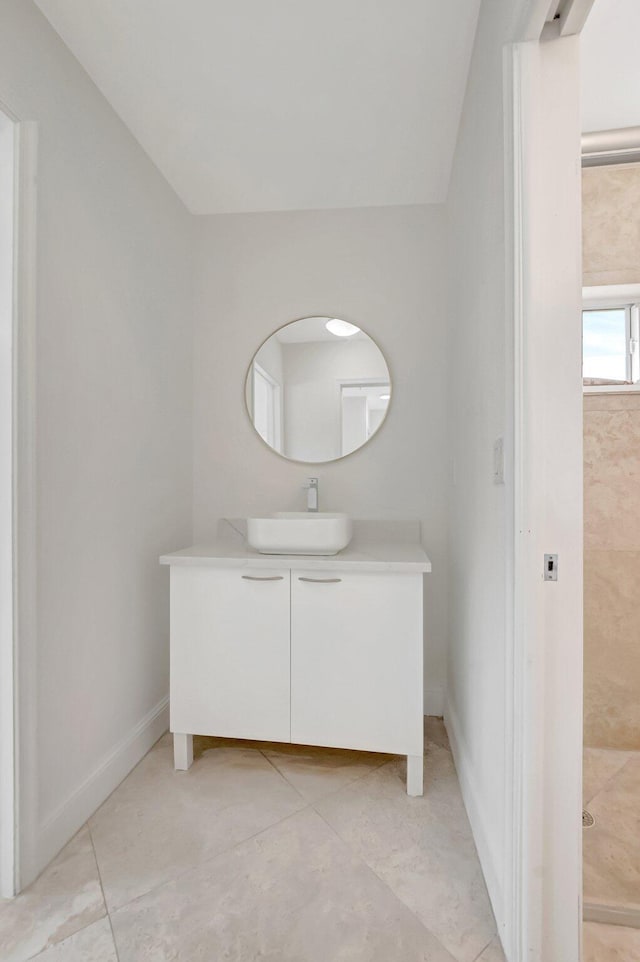 bathroom with vanity, baseboards, and tile patterned floors