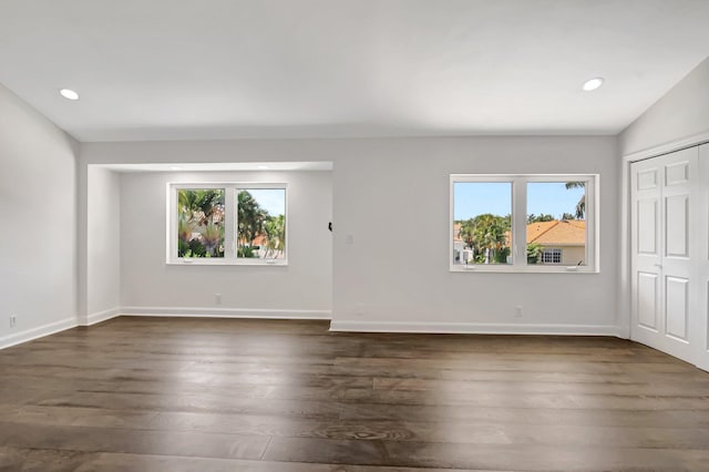 unfurnished room featuring healthy amount of natural light, dark wood-style floors, baseboards, and recessed lighting