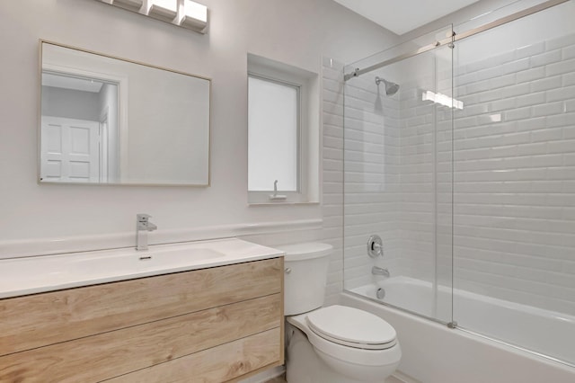 bathroom with toilet, vanity, and shower / bath combination with glass door