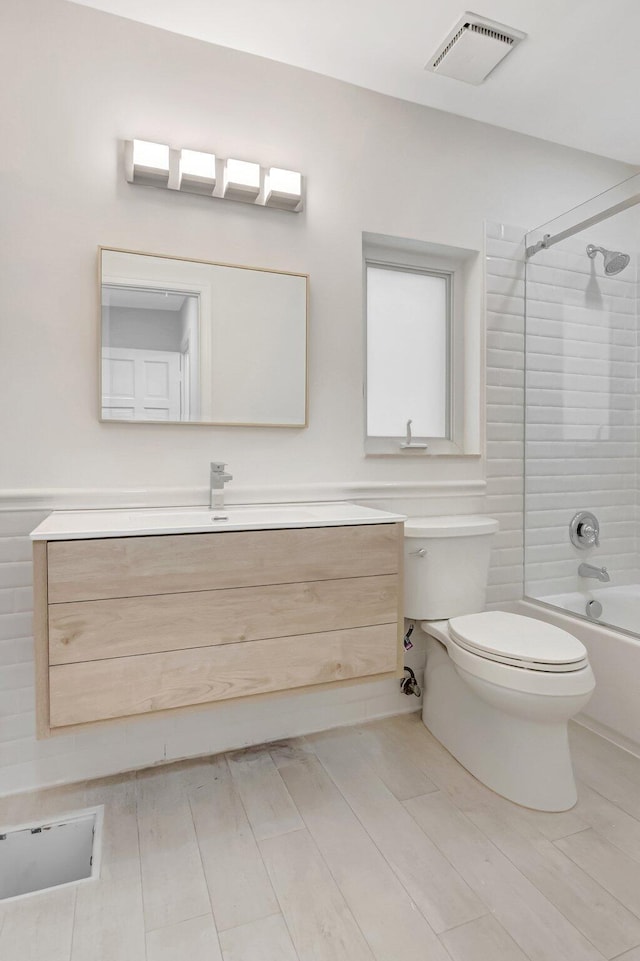 bathroom with toilet, vanity, washtub / shower combination, and wood finished floors