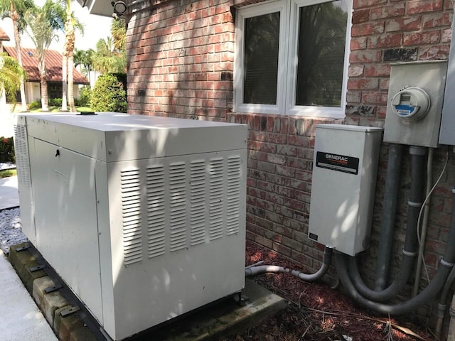exterior view of electric meter, brick siding, and a power unit