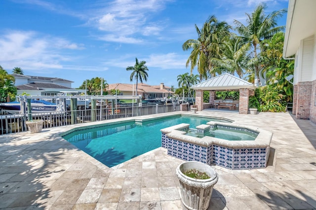 view of swimming pool featuring a gazebo, a patio, a pool with connected hot tub, and fence