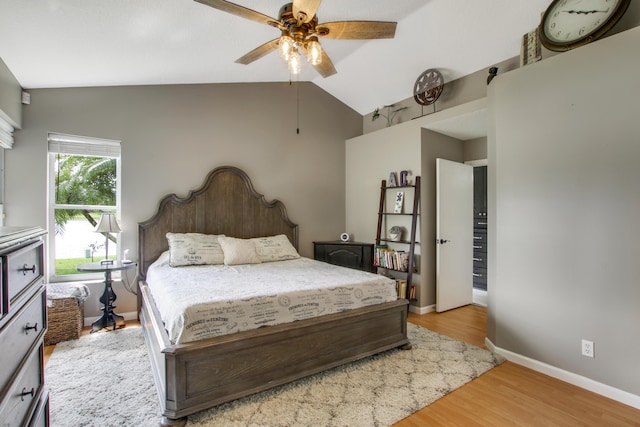 bedroom with lofted ceiling, wood finished floors, baseboards, and ceiling fan