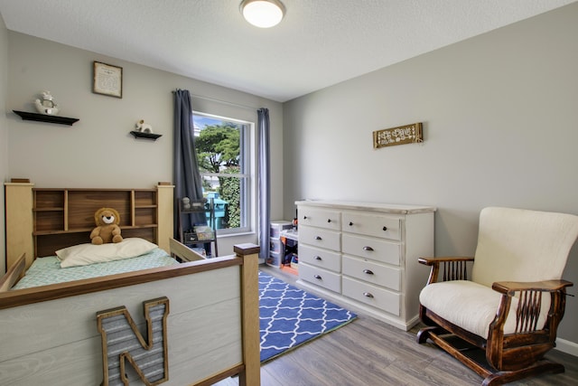 bedroom featuring wood finished floors and a textured ceiling