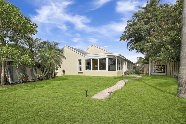 back of property featuring stucco siding and a sunroom