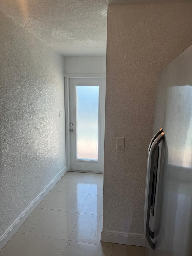 4420 NW 34th St, Lauderdale Lakes, FL 33319 - laundry area with a textured wall, baseboards, a textured ceiling, and light tile patterned floors