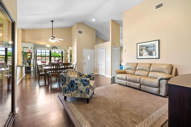 living area with hardwood / wood-style flooring, a ceiling fan, and high vaulted ceiling