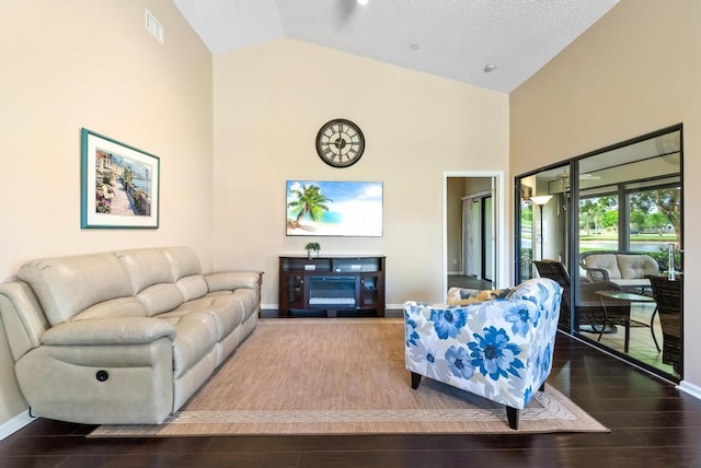 living room featuring high vaulted ceiling, baseboards, and dark wood-type flooring